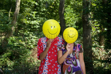 Freiburg  Deutschland  ein junges Paar mit Luftballons mit Smiley-Gesichtern