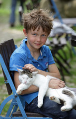 Prangendorf  Deutschland  Junge streichelt eine Katze