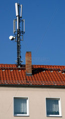 Mobilfunksendemasten auf einem Hausdach