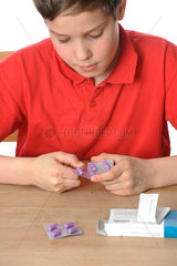 Kind packt Tabletten aus