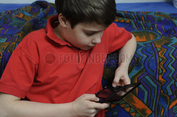 Junge spielt mit Gameboy
