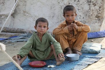 Nowshera  Pakistan  zwei Jungen sitzen vor einem Zelt