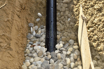Drainagerohr wird  in Steine eingebettet  verlegt.