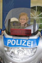 Berlin  Deutschland  kleines Maedchen sitzt auf einem Polizeimotorrad