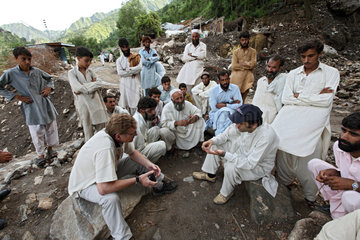 Kokarai  Pakistan  Mitarbeiter einer Hilfsorganisation im Gespraech mit Bewohnern