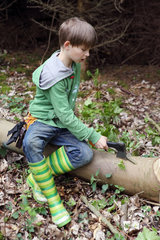 Neu Kaetwin  Deutschland  Junge bearbeitet einen Baumstamm mit einer Axt