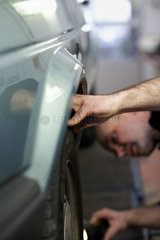 Berlin  Deutschland  TUEV-Mitarbeiter ueberprueft die Reifen eines Autos