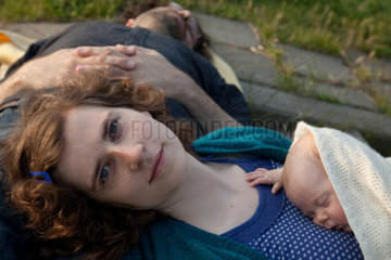 Hamburg  Deutschland  eine Mutter mit ihrem Baby  der Vater schlaeft