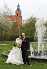 Buckow  Deutschland  Brautpaar schaut gluecklich zum Betrachter
