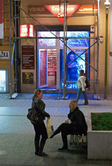 Posen  Polen  Frauen erzaehlen abends in der Fussgaengerzone  dahinter ein Erotik-Shop