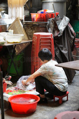 Hongkong  China  eine Frau putzt am Boden Gemuese in einer Garkueche