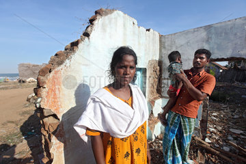 Alikuppam  Indien  eine Familie steht in ihrem vom Tsunami zerstoerten Haus