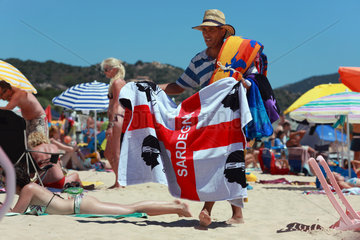 Santa Margherita di Pula  Italien  Mann verkauft ein Handtuch mit der sardischen Fahne am Strand