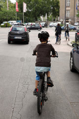 Berlin  Deutschland  Kind faehrt mit seinem Fahrrad auf der Strasse