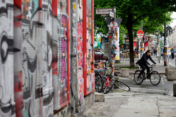 Berlin  Deutschland  Radfahrerin und Graffiti an Rollaeden in der Oranienstrasse