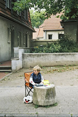 Junge macht Hausaufgaben auf der Strasse
