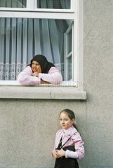 Tuerkische Frau mit Tochter am Fenster