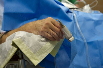 Hand eines Patienten bei OP mit Sauerstoff-Saettigungs-Messgeraet