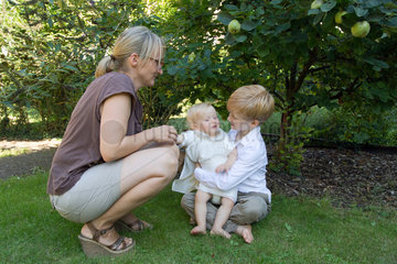 Saarbruecken  Deutschland  Mutter mit ihren beiden Kindern im Garten