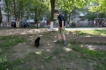 Lemberg  Ukraine  Junge und Katze in einem Stadtteil mit Hochhaussiedlungen