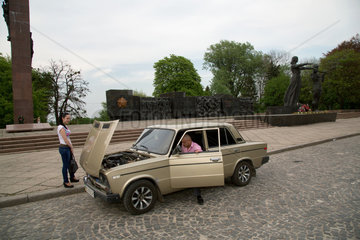 Lemberg  Ukraine  junger Mann schraubt an seinem goldenem Lada