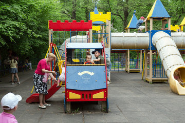 Lemberg  Ukraine  Spielplatz in einem Park  Oma beaufsichtigt die Enkel