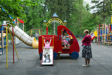Lemberg  Ukraine  Spielplatz in einem Park  Oma beaufsichtigt die Enkel