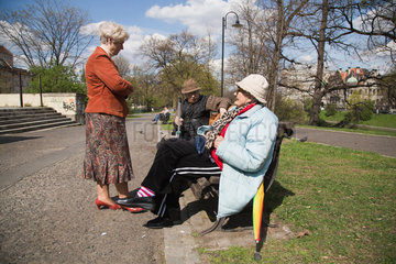 Breslau  Polen  Rentner auf einer Bank in den Wallanlagen begruessen eine Nachbarin