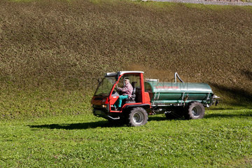 Davos Monstein  Schweiz  Bauer bringt Guelle auf einem Feld aus