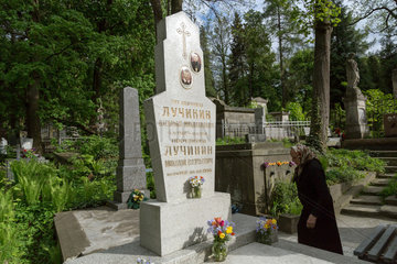 Lemberg  Ukraine  Frau an einem ukrainisch-orthodoxen Grab auf dem Lytschakiwski-Friedhof