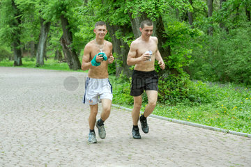 Lemberg  Ukraine  zwei junge Maenner joggen in einem Park