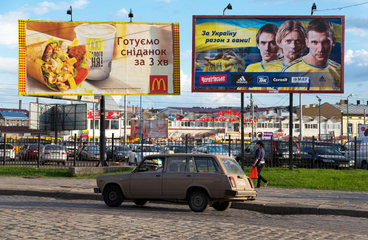 Lemberg  Ukraine  ein Lada faehrt an Werbetafeln vorbei