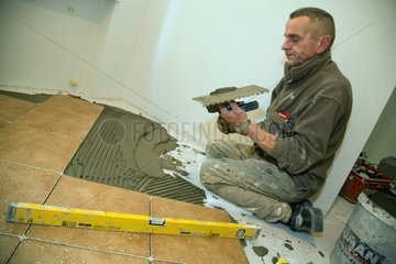 Posen  Polen  Handwerker legt Fliesen bei der Sanierung einer Wohnung