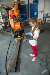 Posen  Polen  Studentin demonstriert die Arbeit mit einem Industrieroboter