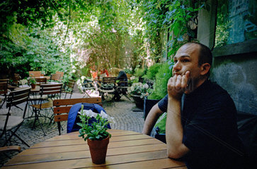 Posen  Polen  ein Mann sitzt im Garten eines Cafes und wartet
