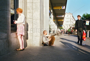 Berlin  Deutschland  ein Obdachloser bettelt neben einem Geldautomaten