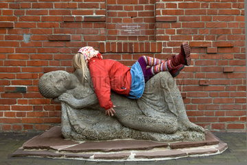 Worpswede  Deutschland  ein Maedchen liegt auf einer Skulptur von Bernhard Hoetger