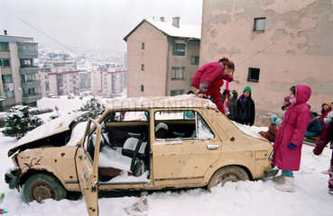 Sarajevo  Bosnien-Herzegowina  Kinder spielen auf einem zerschossenem Auto