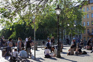 Berlin  Deutschland  junge Leute sitzen auf der Admiralbruecke in der Sonne