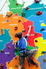 Berlin  Deutschland  an Junge an einer Kletterwand  der die Bundeslaender zeigt