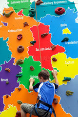 Berlin  Deutschland  an Junge an einer Kletterwand  der die Bundeslaender zeigt