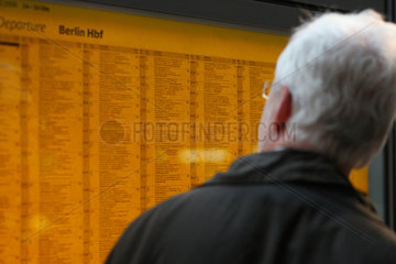 Berlin  Deutschland  aelterer Mann liest die Abfahrtszeiten der Zuege