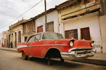 Cienfuegos  Kuba  roter Chevrolet mit fehlenden Raedern