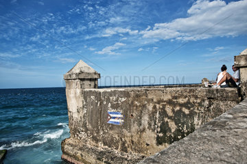 Havanna  Kuba  ein Paerchen auf einer Mauer an der Uferpromenade Malecon