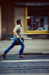 Berlin  DDR  Mann rennt in Eile eine Strasse entlang