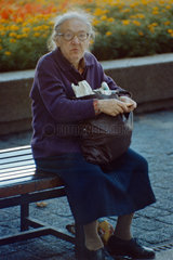 Berlin  DDR  Seniorin sitzt gedankenverloren auf einer Parkbank