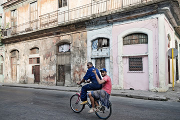 Havanna  Kuba  Strassenszene mit zwei Maennern auf einem Fahrrad