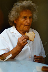 Berlin  DDR  alte Frau isst ein Stueck Sandkuchen