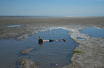 Sankt Peter-Ording  Deutschland  ein Kind schnorchelt im flachen Wasser am Strand von Boehl