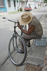 Santiago de Cuba  Kuba  ein Mann repariert sein Fahrrad